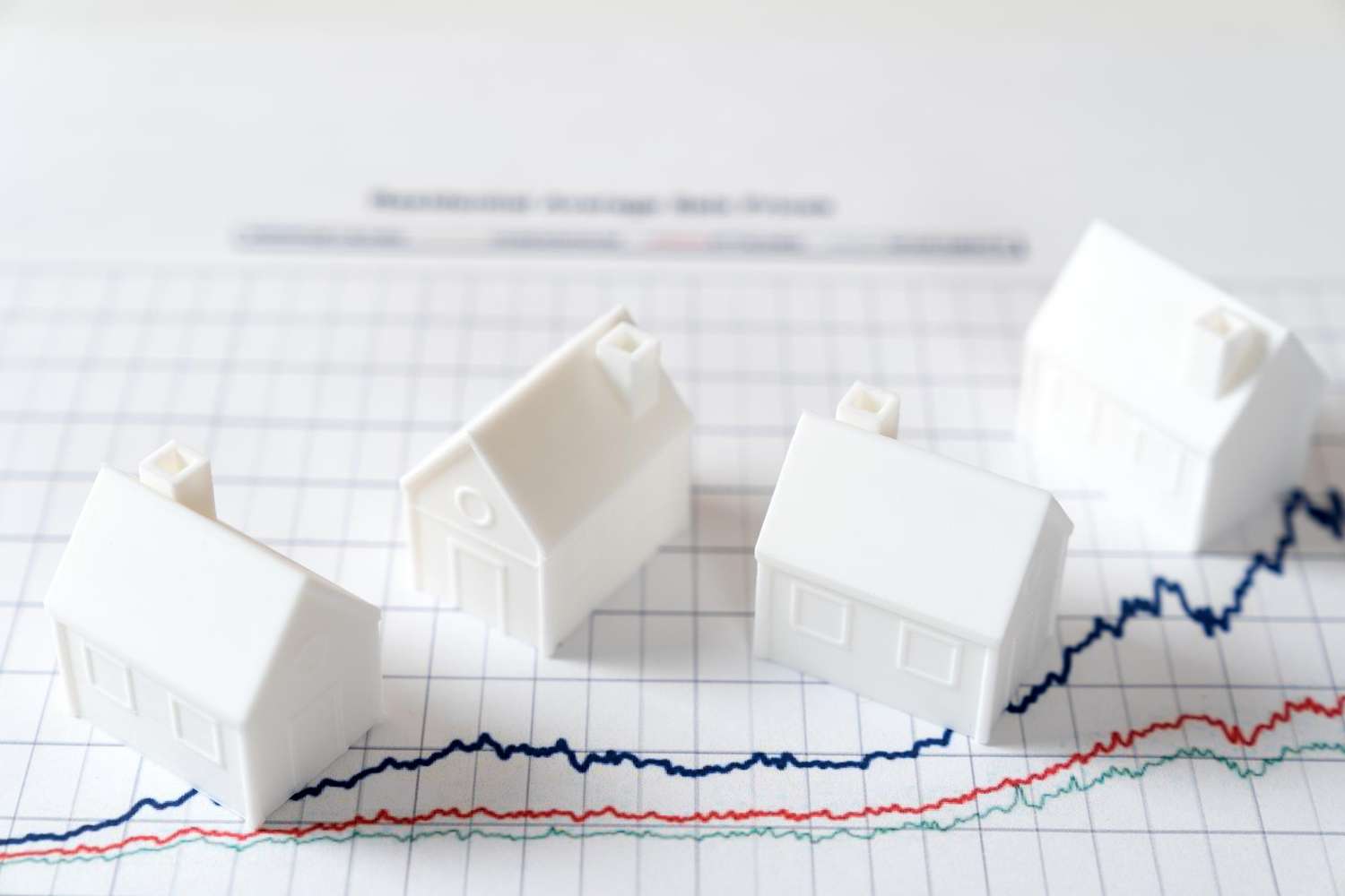 Tiny houses over a graph illustrating the housing market